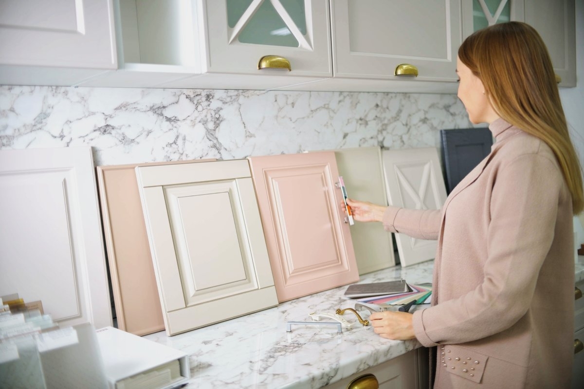 image showing woman choosing among different kinds of cabinet doors styles and colors