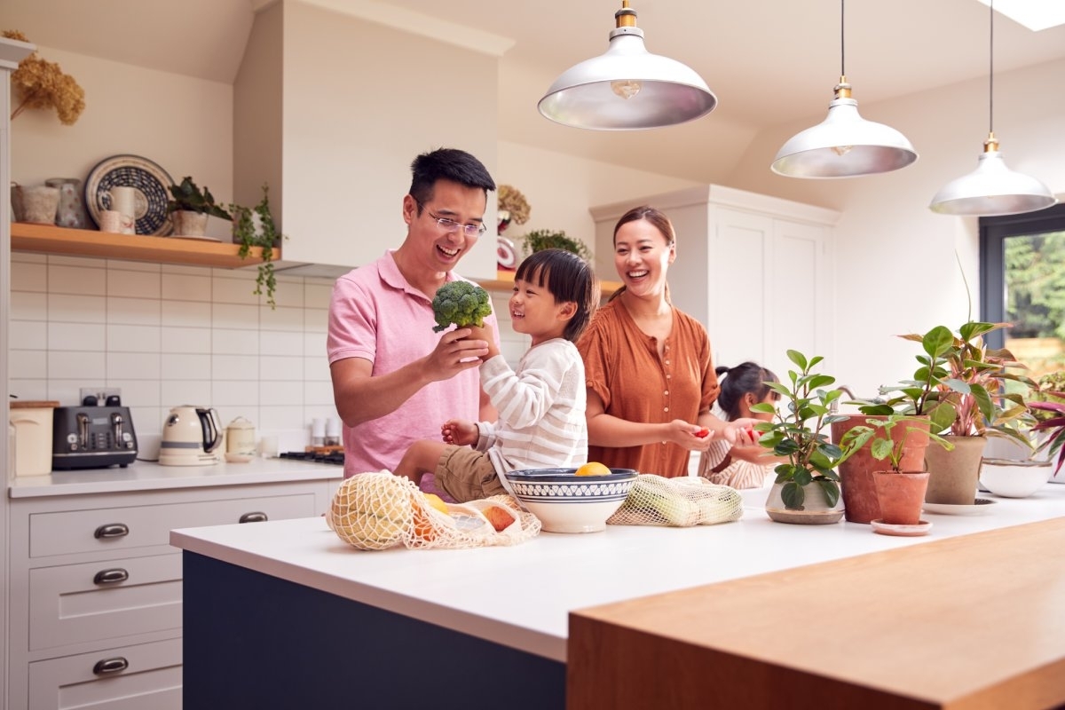 image showing family eating vegetables and fruit in the kitchen