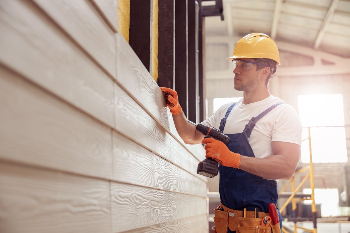 image showing a professional replacing siding