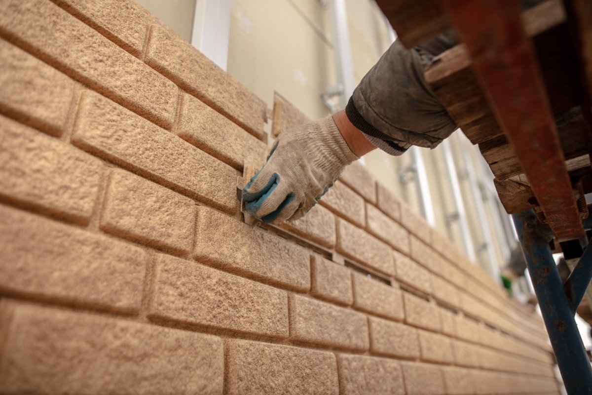 image showing professional working on a siding made of bricks