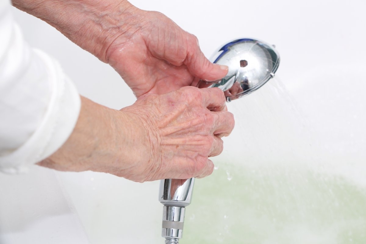 image showing a shower handle held by a hand