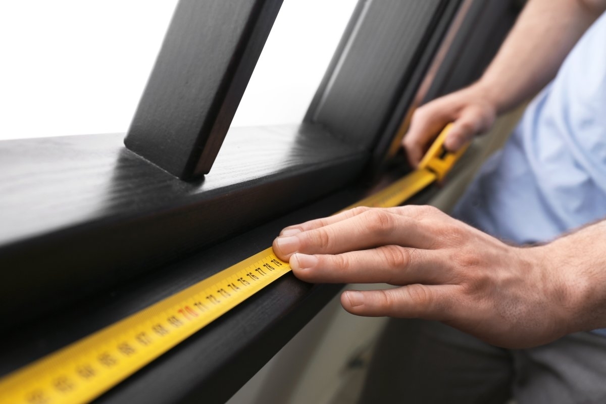 image showing a hand with tape to measure a window