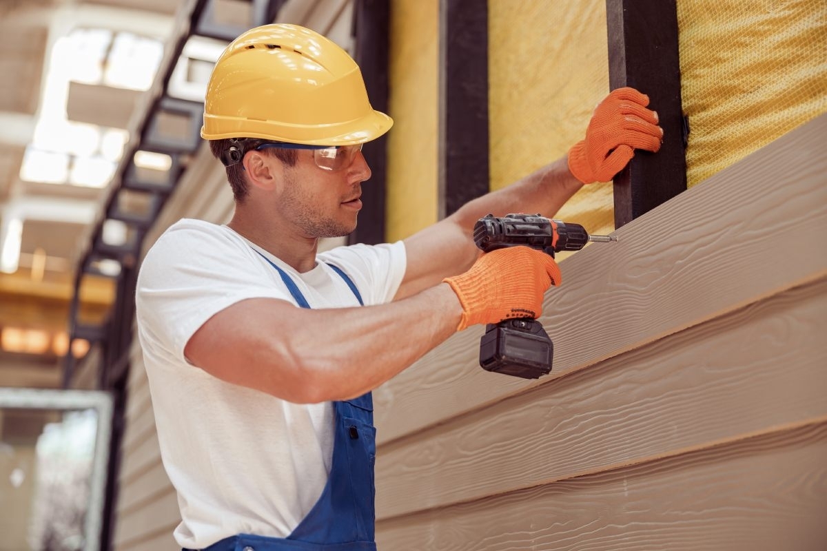 image showing installer replacing house siding with engineered wood material