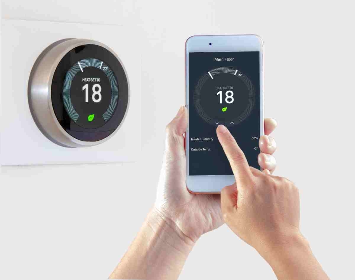 image that shows a hand using a smart thermostat
