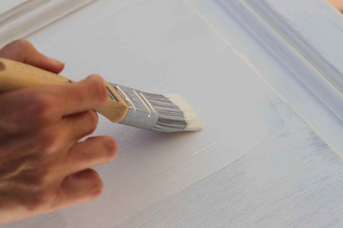 image showing someone painting kitchen cabinets