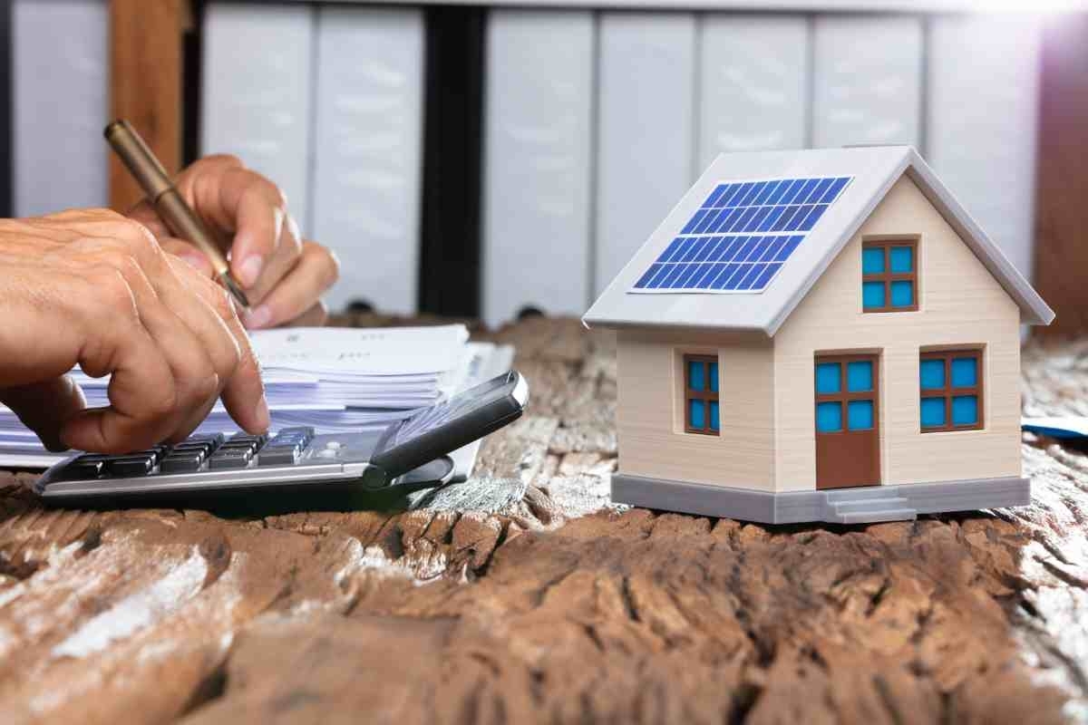 image showing a small house with solar panels and a calculator