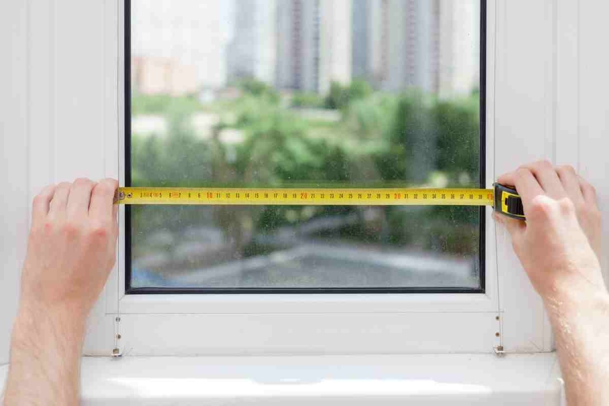 image showing two hands measuring a window from indoor