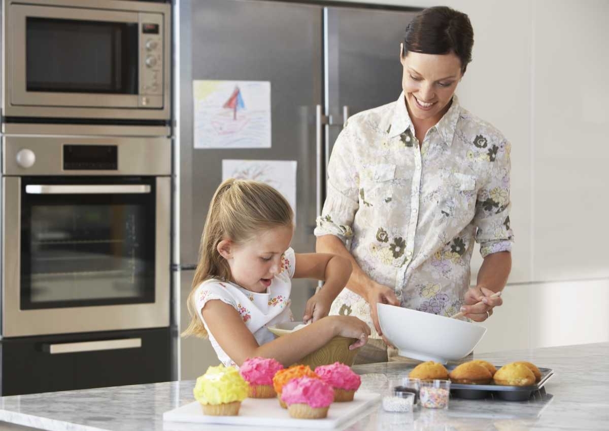 image showing an happy mother with her daughter in their kitchen while cooking