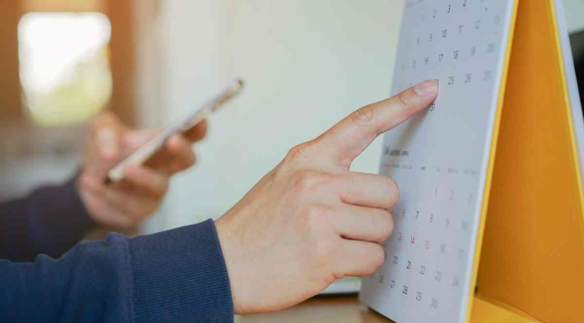 image showing hand choosing a date on a table calendar
