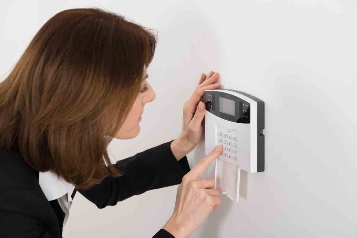 image showing woman using control panel of home security system