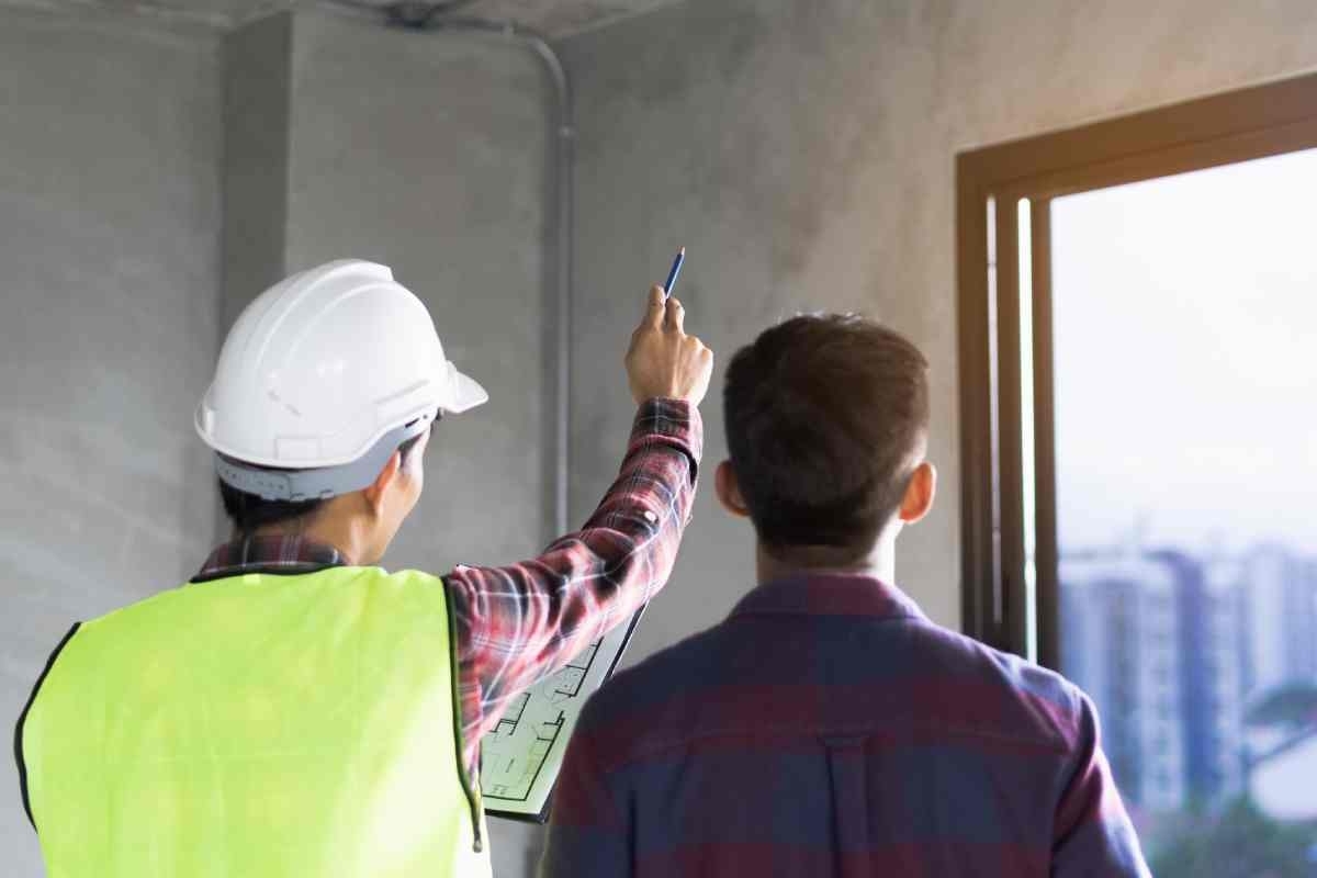 image showing a contractor and a homeowner discussing while the contractor is pointing at the window