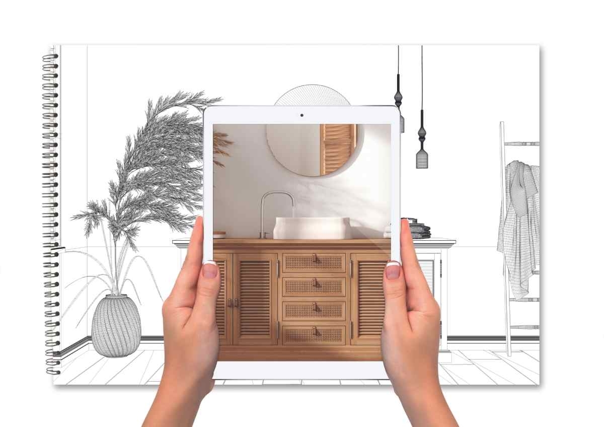image showing a notebook with a bathroom design on it, framed in a tablet held by a pair of hands