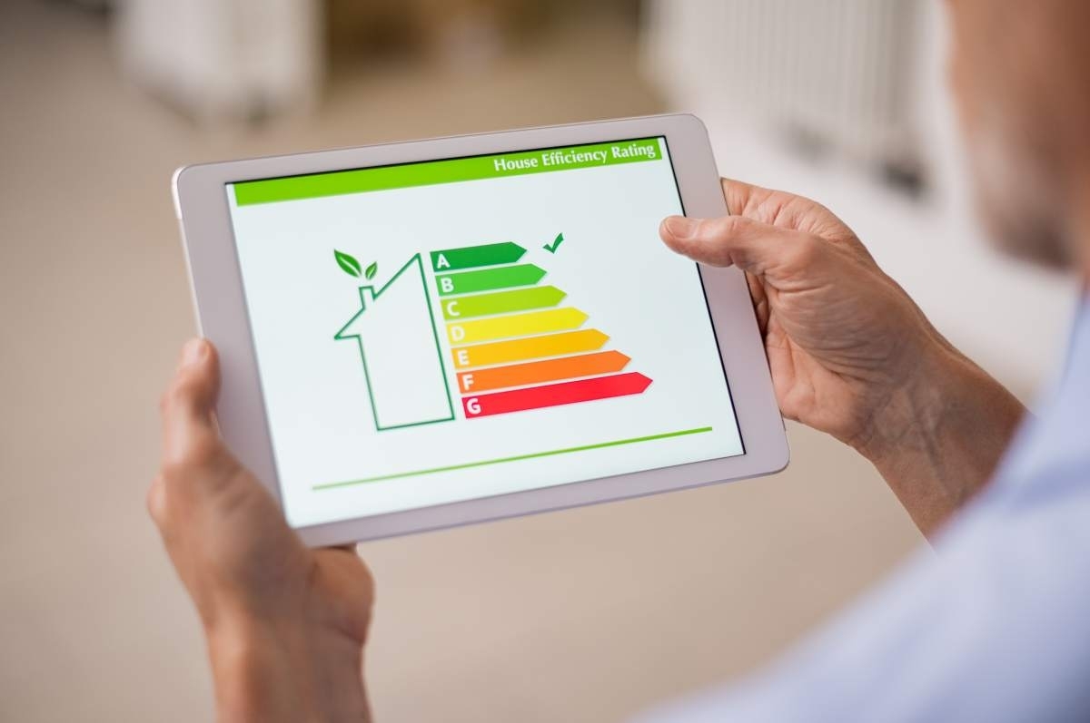 image showing a han d holding a tablet that shows how energy efficient the house is