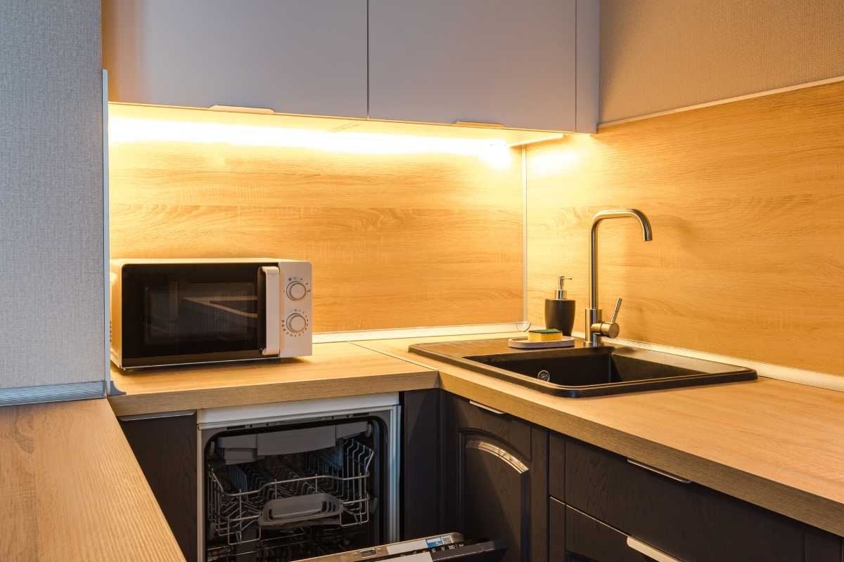 image showing a small kitchen with sink and dishwasher integrated