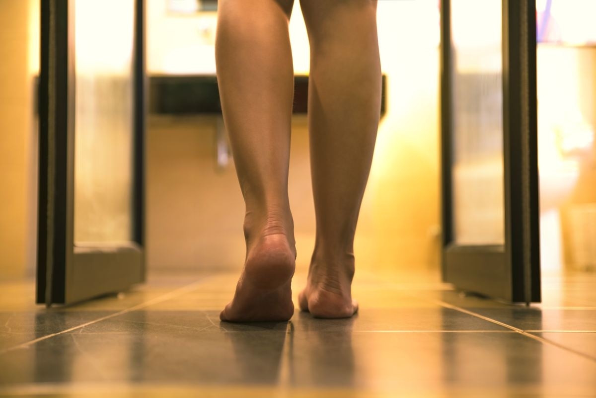 image showing human feet walking in shower