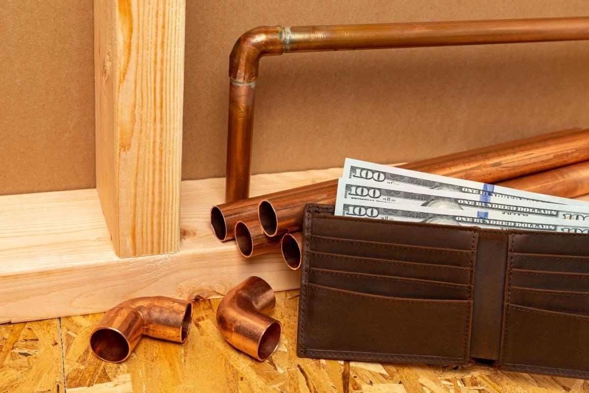 image showing some pipes and a wallet with dollars in it