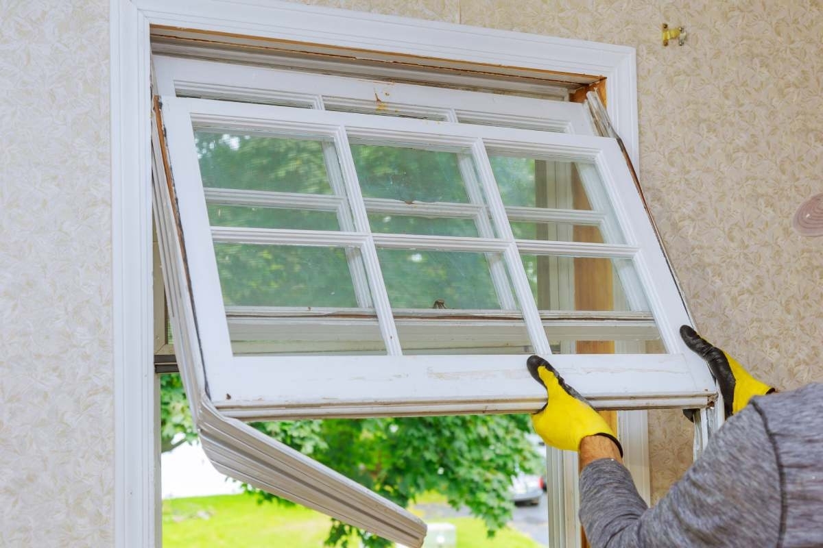 hands of professional replacing a old window