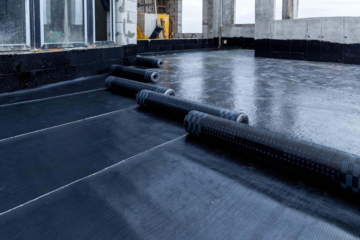 flat roof in dark colors being covered by a roof cover