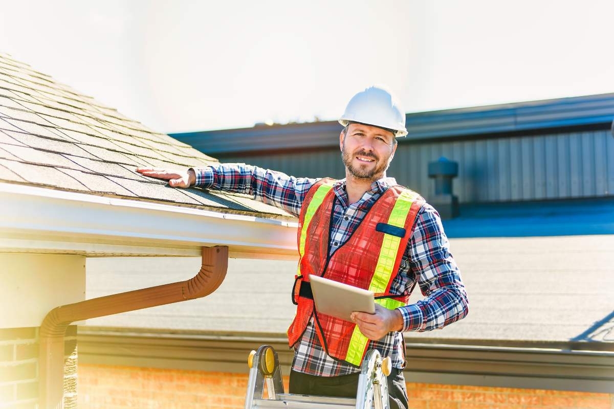 roofing expert touching a roof in the sun