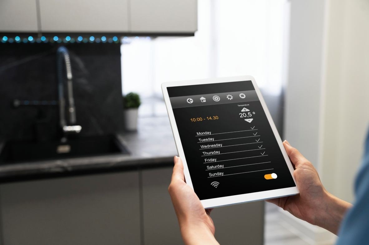Smart kitchen control: hands holding iPad with weekly schedule.