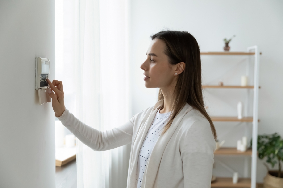 image showing woman managing her home security system via her control panel