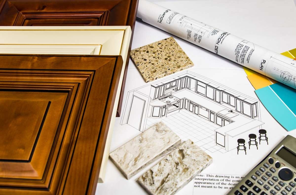 drawing of a kitchen on a table with some tools for measurement and some materials sample