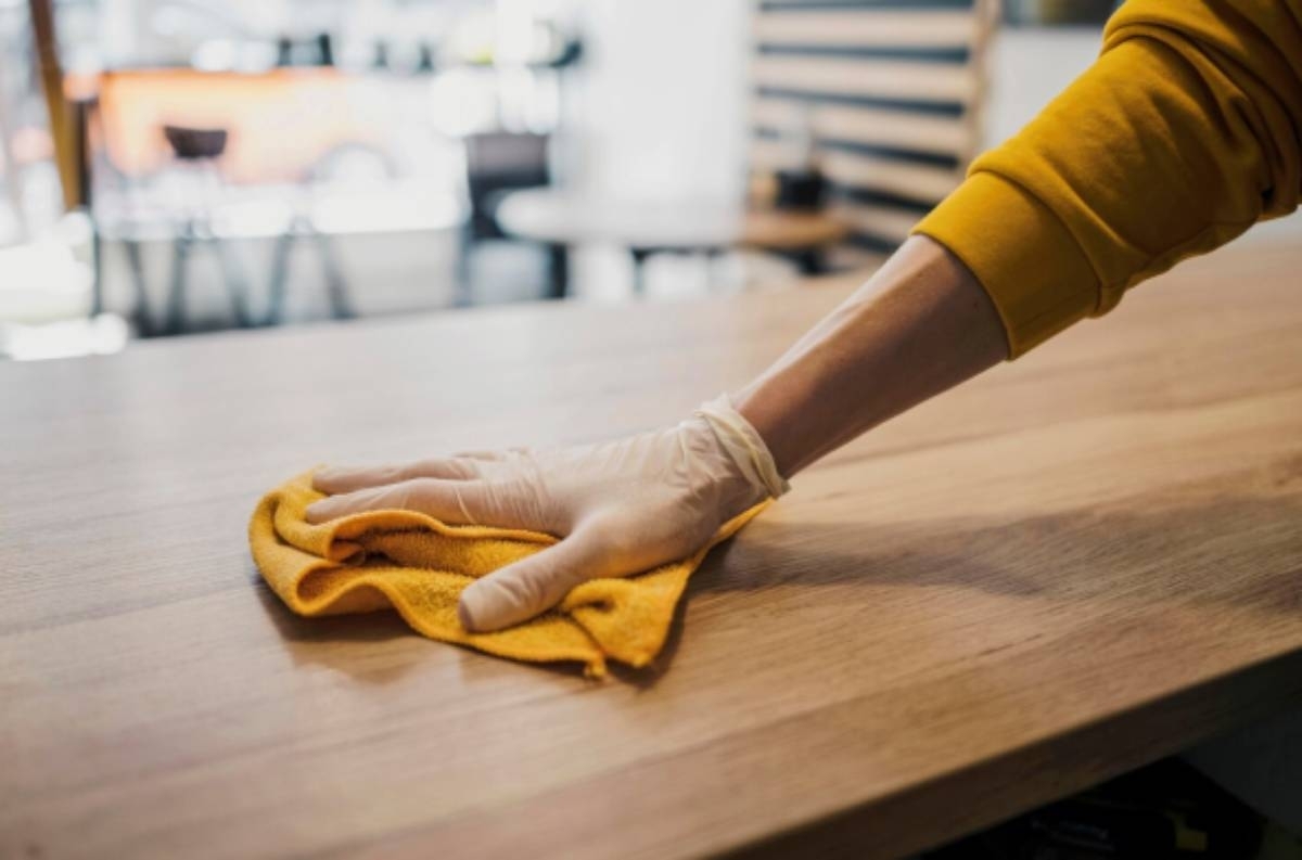 hand cleaning a wood cabinet 